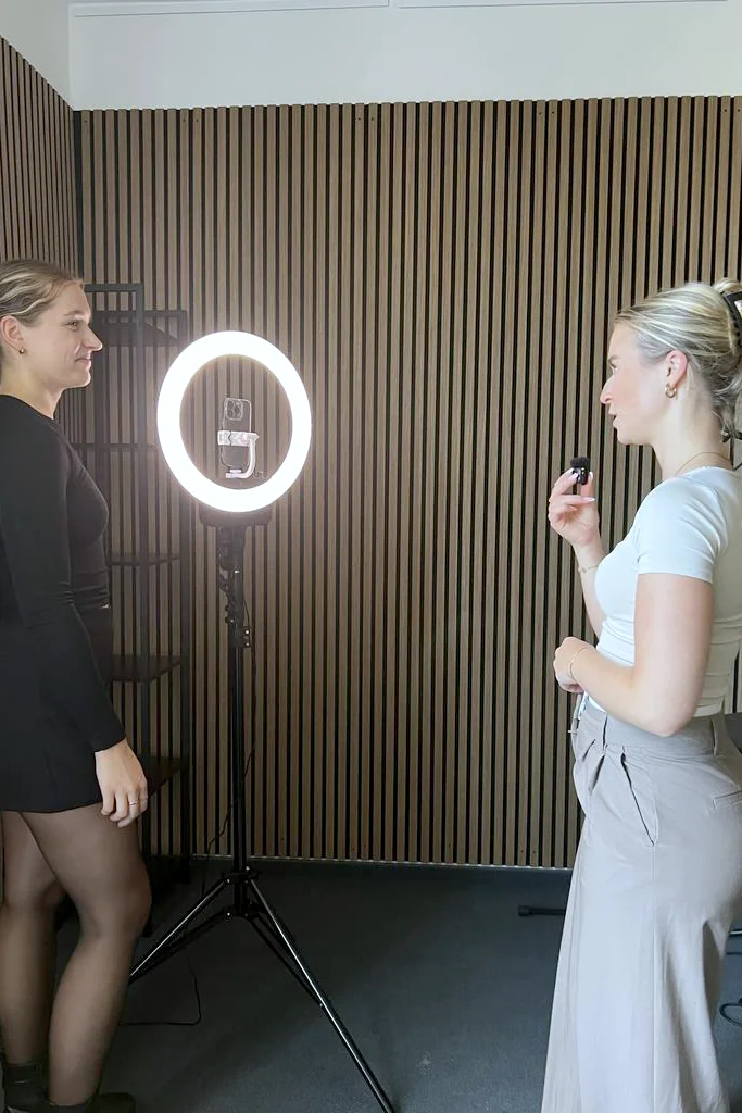 Zwei Kolleginnen von schmidtmedia bei einer Video-Aufnahme am Ringlicht im Studio