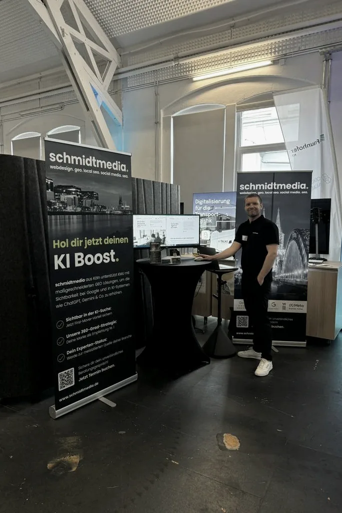 Mitarbeiter von schmidtmedia am Messestand mit KI-Boost-Rollup auf einem Digitalisierungs-Event