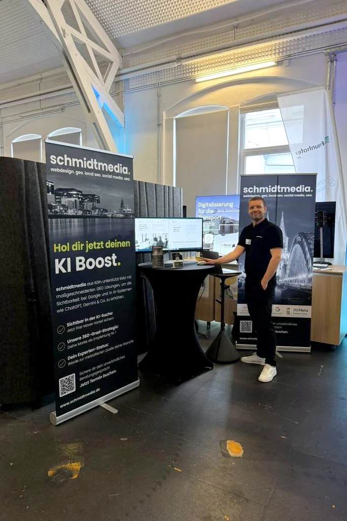 Mitarbeiter von schmidtmedia am Messestand mit KI-Boost-Rollup auf einem Digitalisierungs-Event