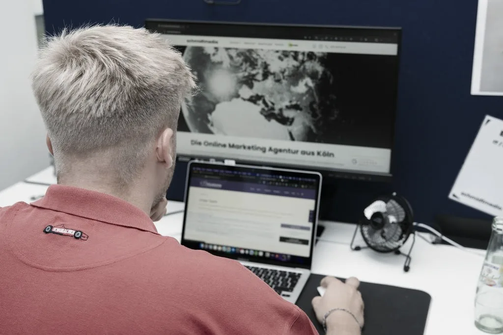 Webdesigner von schmidtmedia arbeitet an zwei Bildschirmen an einer Website
