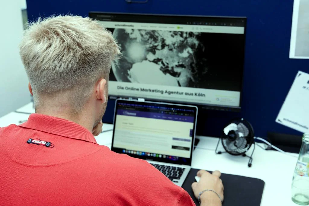 Webdesigner von schmidtmedia arbeitet an zwei Bildschirmen an einer Kundenwebsite